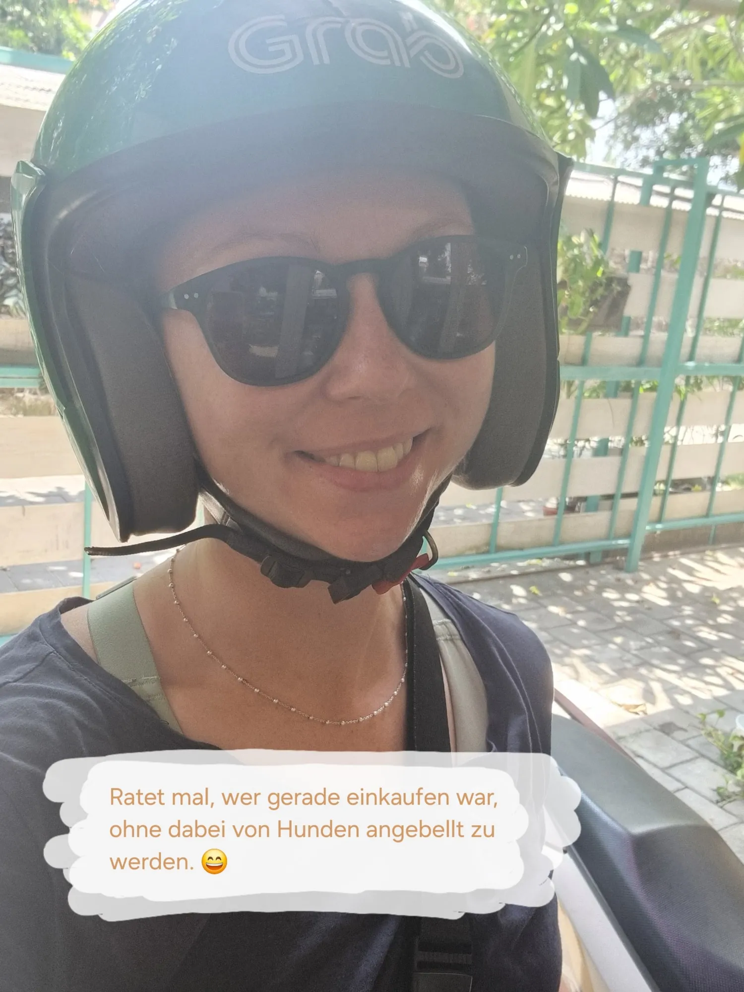 Pauline auf einem Motorroller, mit hellgrünem Helm und Sonnenbrille, lachend in die Kamera. Text im Bild: „Ratet mal, wer gerade einkaufen war, ohne dabei von Hunden angebellt zu werden.“